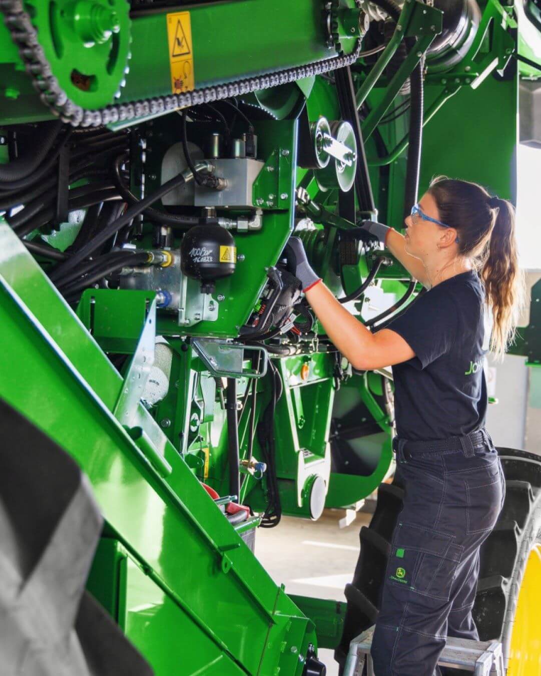 Nainen korjaamassa traktoria.