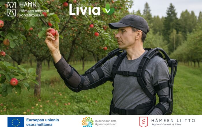 Lippalakkipäinen mies poimimassa omenoita pukeutuneena eksoskeletoniin.